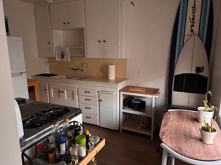 A cleverly small kitchen table leaves room for the surfboards....