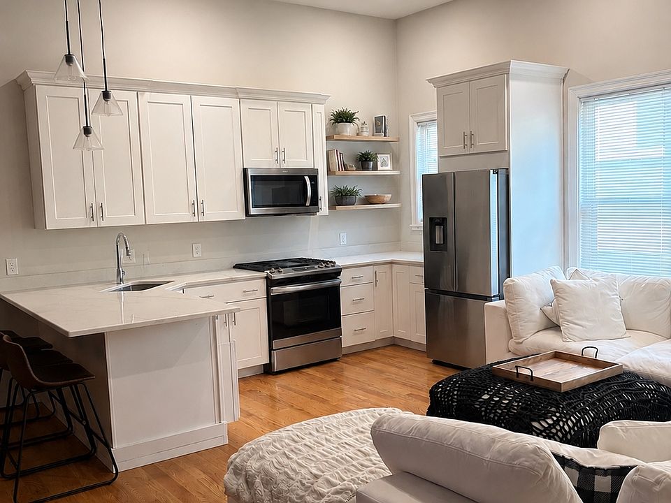 Granite/Stainless kitchen. with white cabinetry. Dishwasher, disposal, gas cooking, 10-foot ceilings, gorgeous. exposed brick.