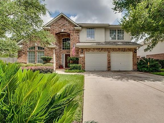 Surrounded by lush landscaping and towering trees...