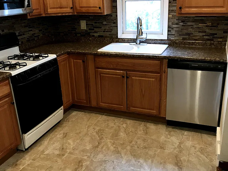 Kitchen with stainless steel dishwasher and microwave.