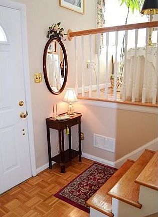 Entry foyer has a parquet floor & hardwood stairs