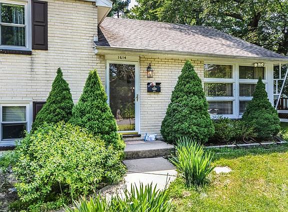Mature landscaping frames the front door