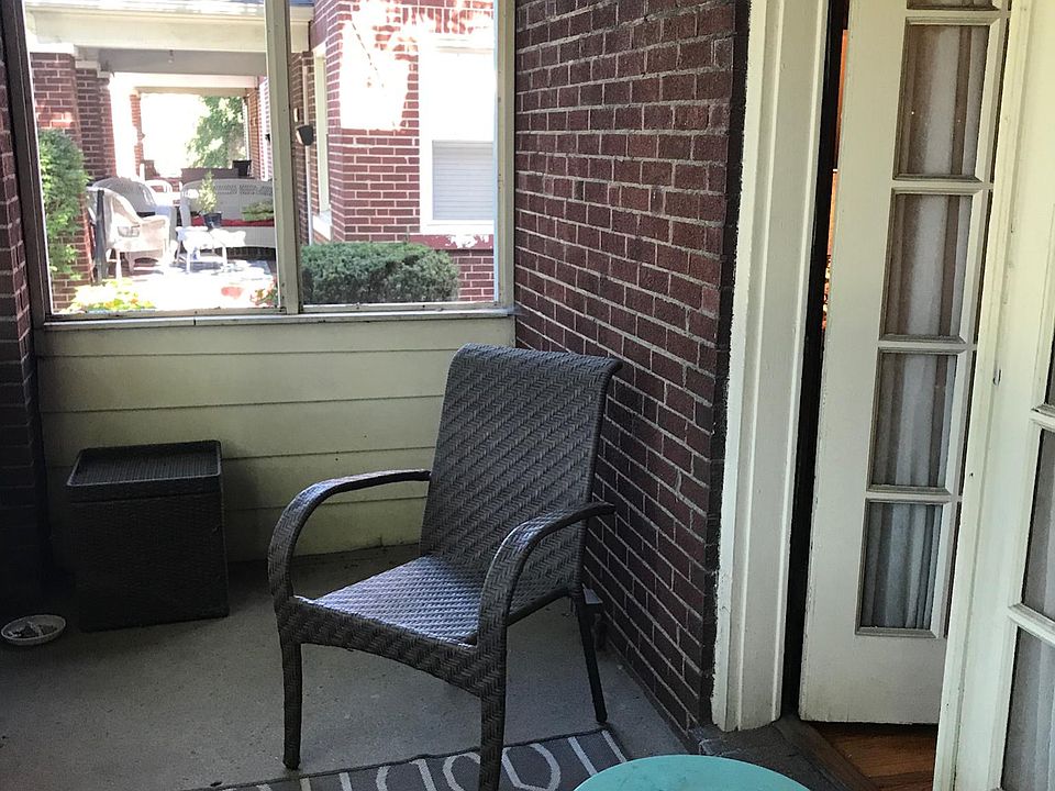 Screened-in front porch looks out onto century old oak trees