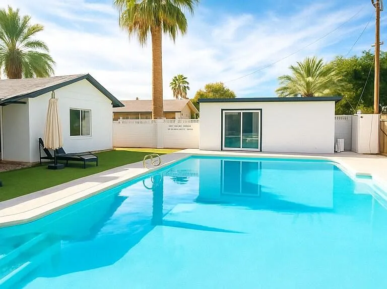 Resort-style backyard with a large swimming pool, lounge area, and privacy fencing for relaxing outdoor time.