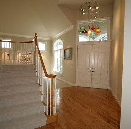 Soaring ceiling entry, gleaming hardwood floors, and custom, hand blown glass light fixture provide 