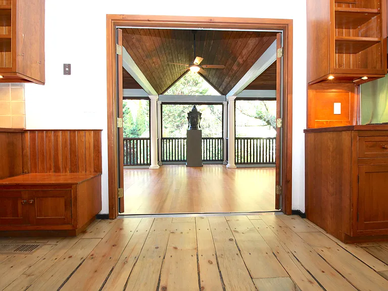 Screen Porch off Kitchen features wood floor and a view of the rear Garden.