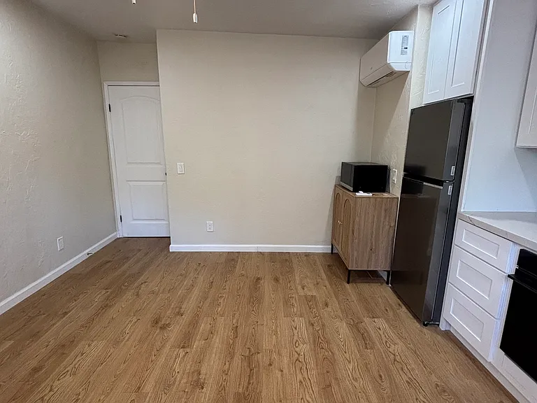 OK to hang TV on wall. Plenty of room for table, chairs, TV, couch, and additional wall storage unit