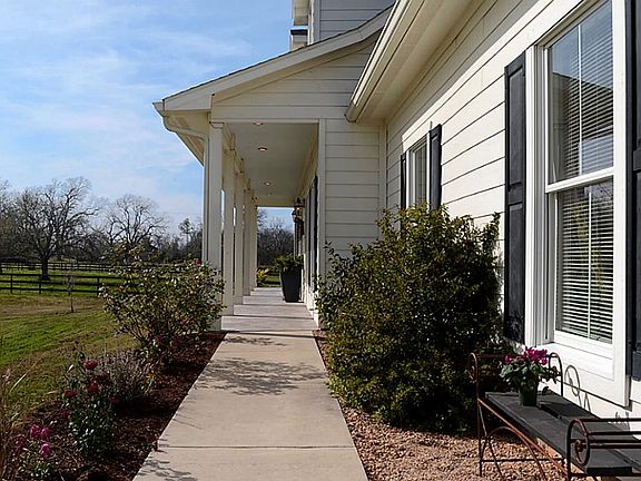 A lovely walk leads friends and Guests to the covered front Porch that measure an impressive 40 feet in length