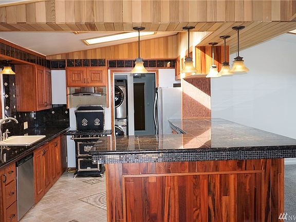 Custom kitchen w/granite, stainless, tile, large breakfast bar - opens to family room/living area.