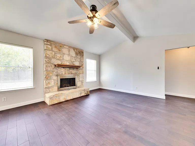 Spacious Living Room: Relax and unwind in the expansive living room complete with vaulted ceilings and a cozy fireplace, creating a warm and inviting atmosphere.