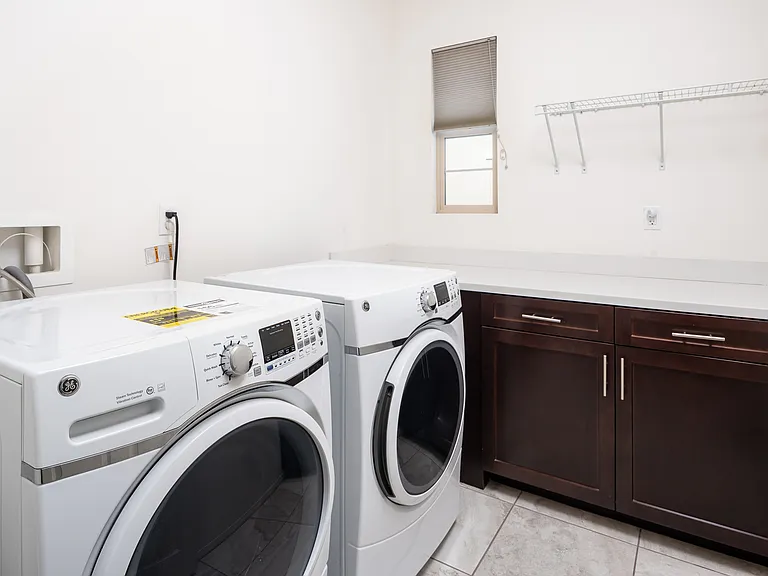 Laundry Room Upstairs with new branded Washer, Dryer and cabinets.