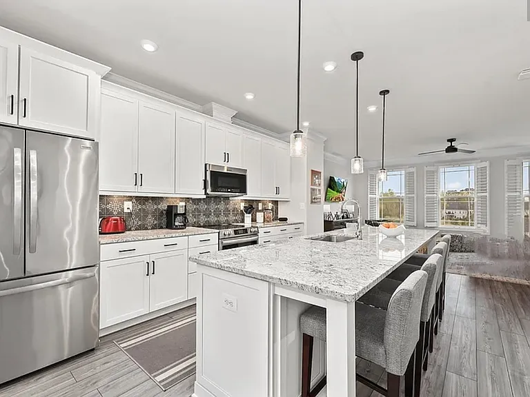 White kitchen cabinets, stainless electric-appliances, tile backsplash, stove directly vented outside. No natural gas