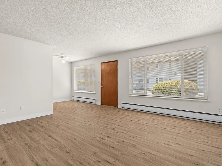 Open living and dining space with large windows in a one-bedroom deluxe apartment at Palisades Apartments in Tacoma. Open living and dining space with large windows in a one-bedroom deluxe apartment at Palisades Apartments in Tacoma.