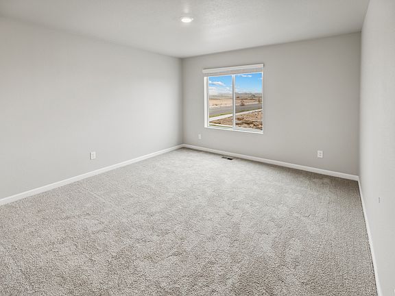 Expansive master bedroom with a window and an attached bathroom.