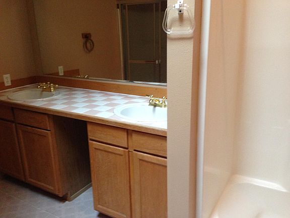 Master bath with double sinks and tile top.