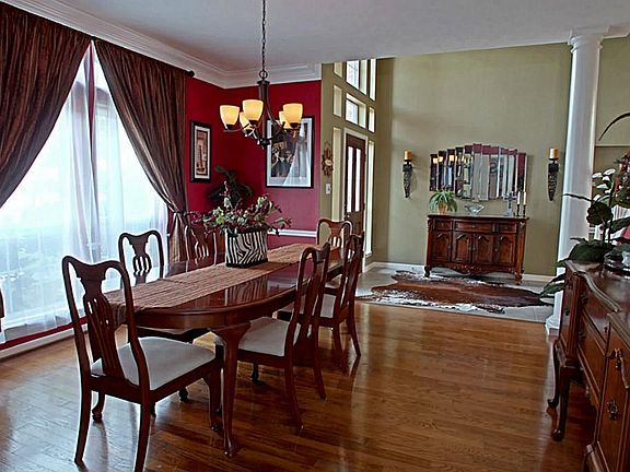 The Dining room is stylish with gleaming hardwood floors, crown molding and elegant lighting fixture. The bold color and custom drapes add a dramatic decorating touch to this room which create a very intimate setting.