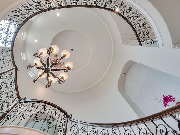 Looking straight up from the center of the foyer reveals a two story cupola with cove lighting set off by an intricate high style railing leading your eye upward.