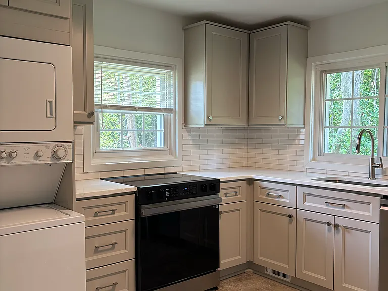 New appliances-glass top electric range. Stacked washer-dryer unit.