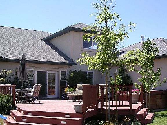 Back yard features large deck for entertaining, a hot tub and nice landscaping