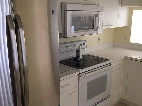 Fully equipped kitchen with stainless steel refrigerator.