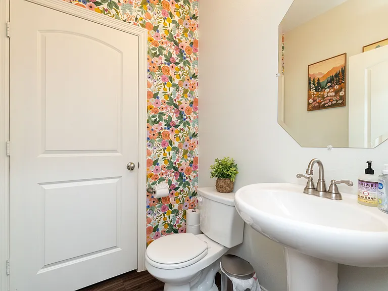 Charming floral half bath with a pedestal sink and mirror_adds a touch of elegance and convenience.