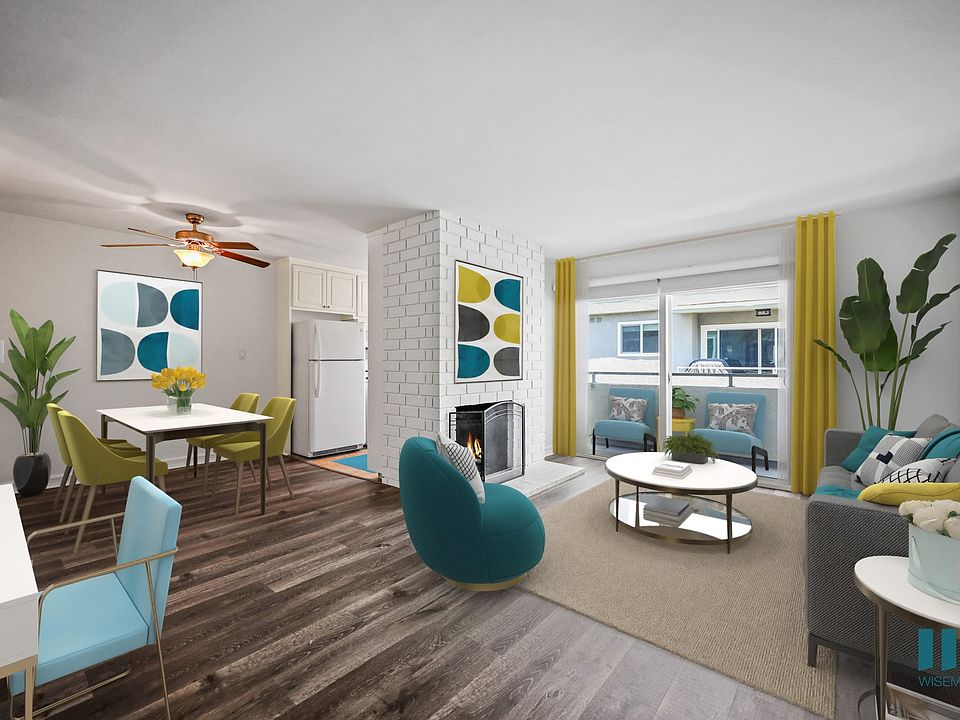 Open-Concept Dining and Living Room with Vinyl Flooring, Fireplace, and a Patio