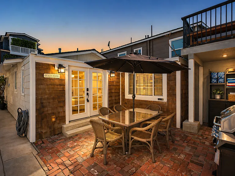 Private patio with outdoor dining and cozy evening lighting