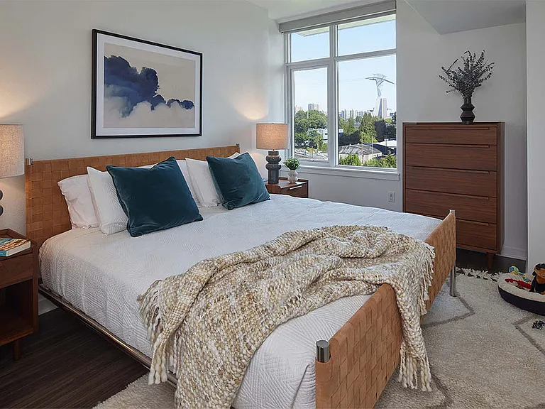 Spacious apartment bedroom with wood-style flooring.