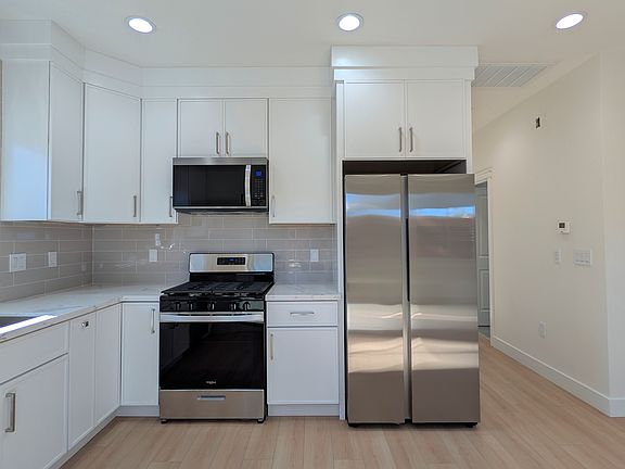 Gourmet chef's kitchen with gas burner, quartz countertops, brand new appliances.