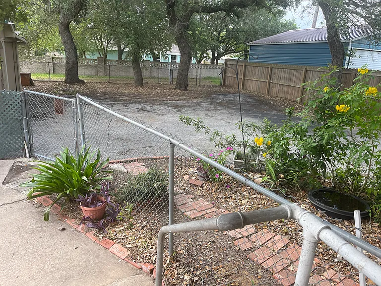 fenced area at rear of home looking at parking area
