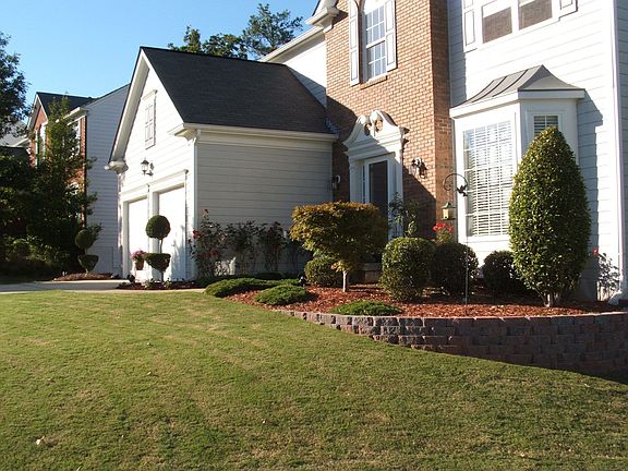 Stone wall. Mature shrubs.