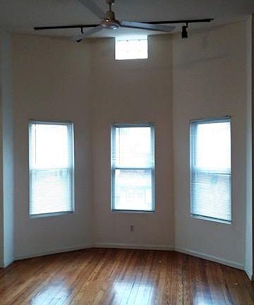 View into the Living room. Bright light and original hardwood floors.