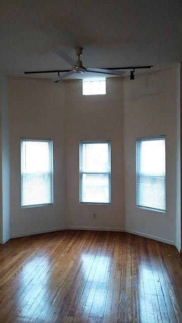 View into the Living room. Bright light and original hardwood floors.