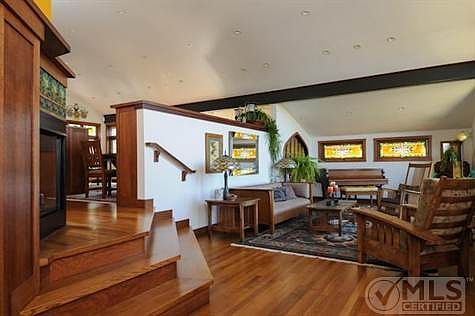 Second floor view from hallway showing living room and peeking into dining room.