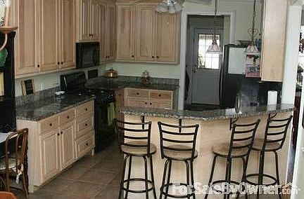Custom cabinets in kitchen : Tile floors, granite countertops, gas stove and whitewashed cabinets
