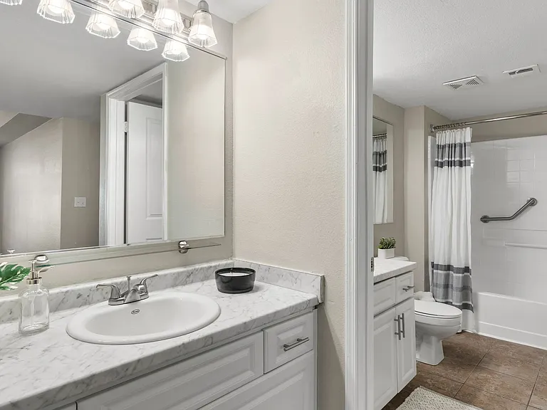 Newly remodeled bathrooms boasting marble-style countertops and ample mirrors.