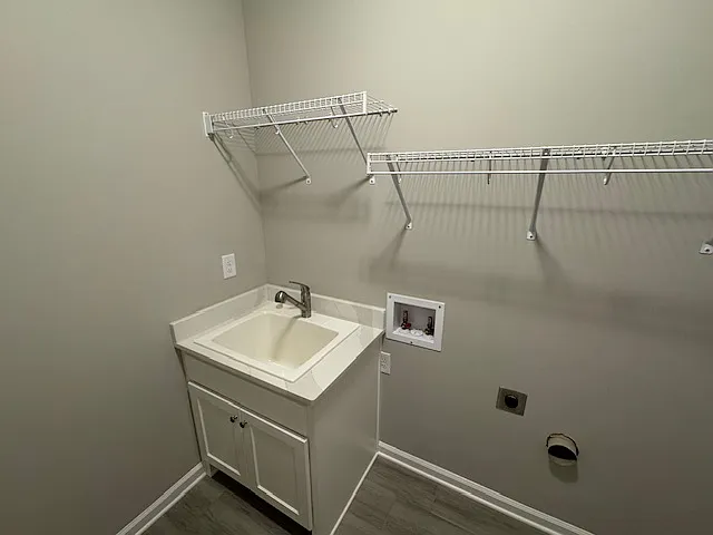 Terrace Level Laundry Room with Laundry Tub, Washer and Dryer hookups and ceramic tiled flooring