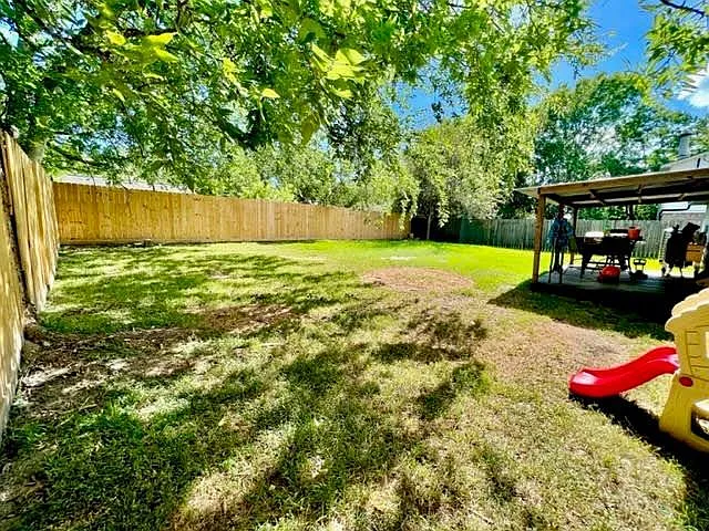 The huge backyard with a covered patio.