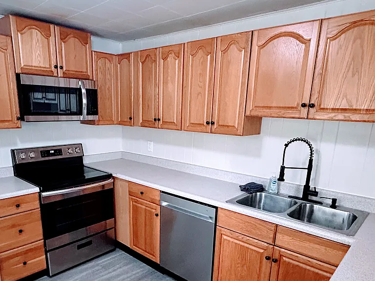 Kitchen with microwave, glass-top stove, dishwasher, and sink
