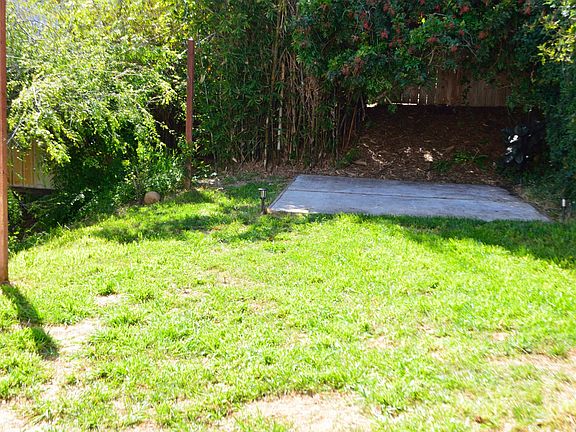 Larger view of back yard with concrete pad for patio and BBQ area