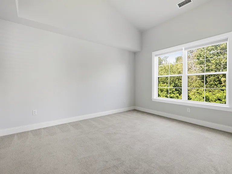 Primary bedroom ensuite features a vaulted ceiling, walk-in closet and faces a serene wooded backdrop so it's pin-drop quiet.