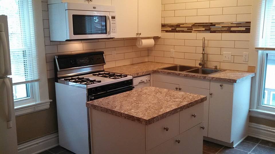 Updated kitchen with rolling (and locking) island, pantry, dishwasher, large sink, stove, microwave, and fridge.