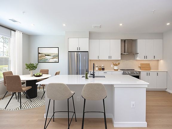 Upgrade Collection 3BR Townhome Kitchen with white cabinetry, white quartz countertops, and over-the-range hood