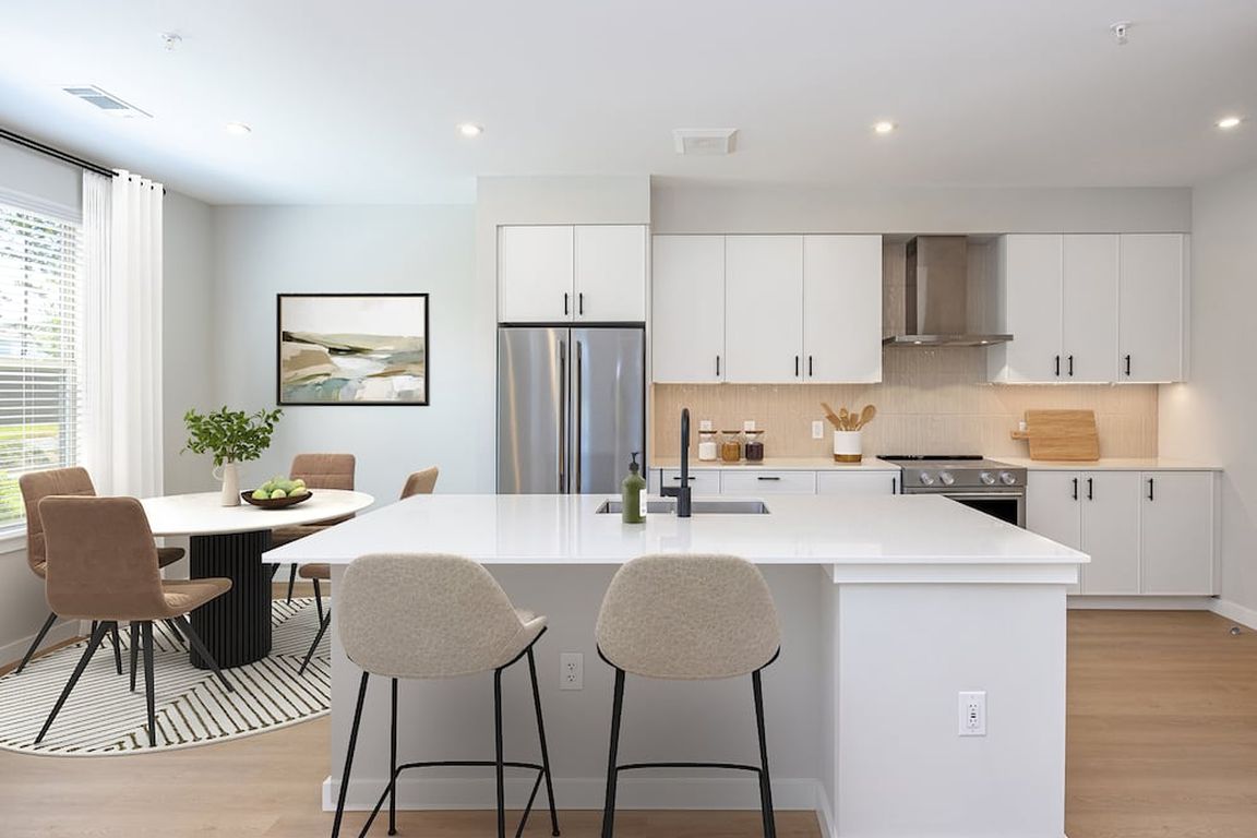 Upgrade Collection 3BR Townhome Kitchen with white cabinetry, white quartz countertops, and over-the-range hood