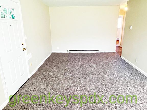 Front door and living room with electric baseboard heat