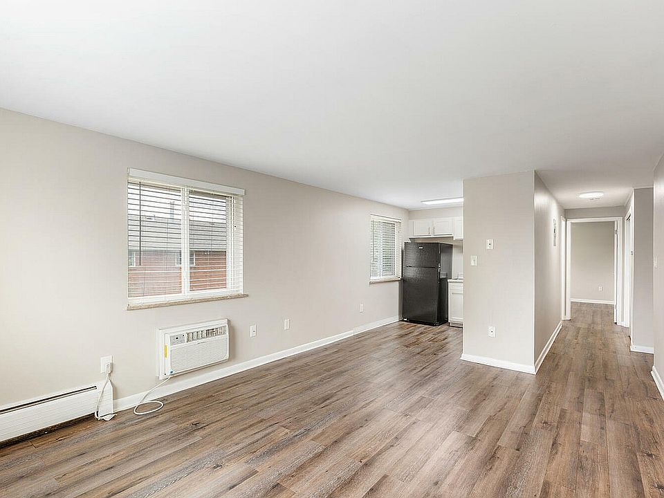 Bright and airy apartment interior with elegant hardwood floors, modern kitchen, and large windows providing abundant natural light.