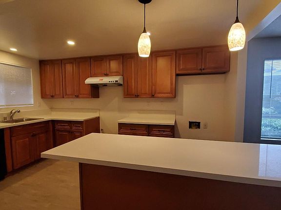 New kitchen with quartz counter tops, tile floor, cabinets and dishwasher.