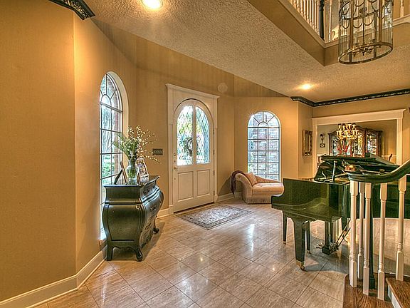 Elegant entry with arched front door and winding staircase.