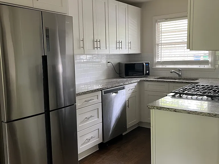 Kitchen with stainless steel appliances and brand new fridge.