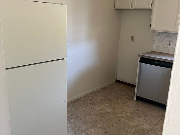 Kitchen. Refrigerator is too large for opening. Previous tenants put a microwave rack in the space,